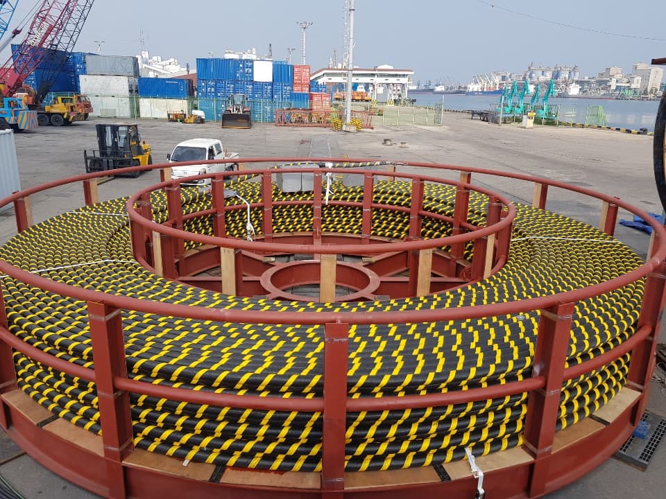 Gulungan kabel pelindung hitam-kuning di pelabuhan