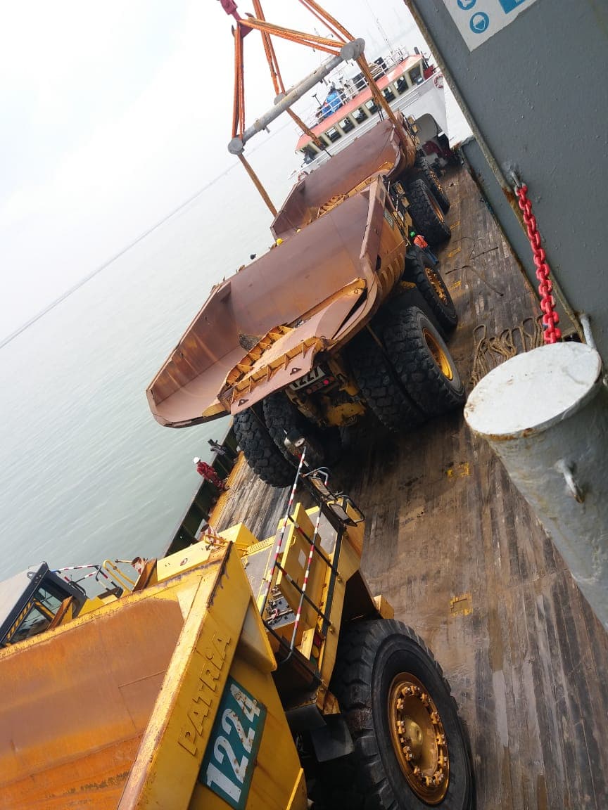 Dua dump truck di dek kapal dalam proses bongkar muat